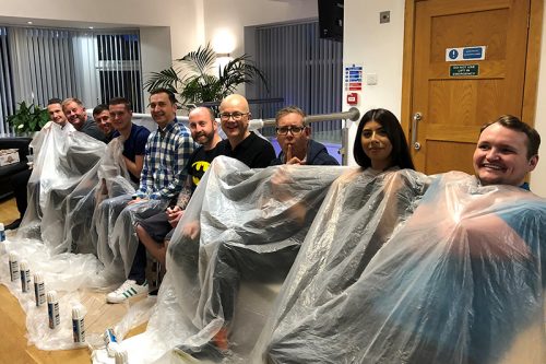 A line-up of willing volunteers ready to be squirty cream pied for charity include CEO Michael Abbott