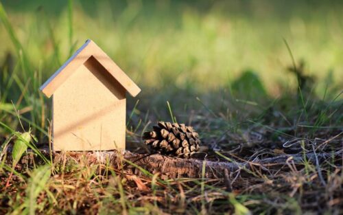 A small toy wooden house in a garden setting