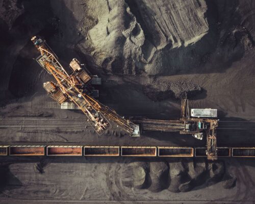 Coal mining. Aerial view. Excavator loading train cargos