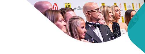 A collection of people at an awards event in evening dress