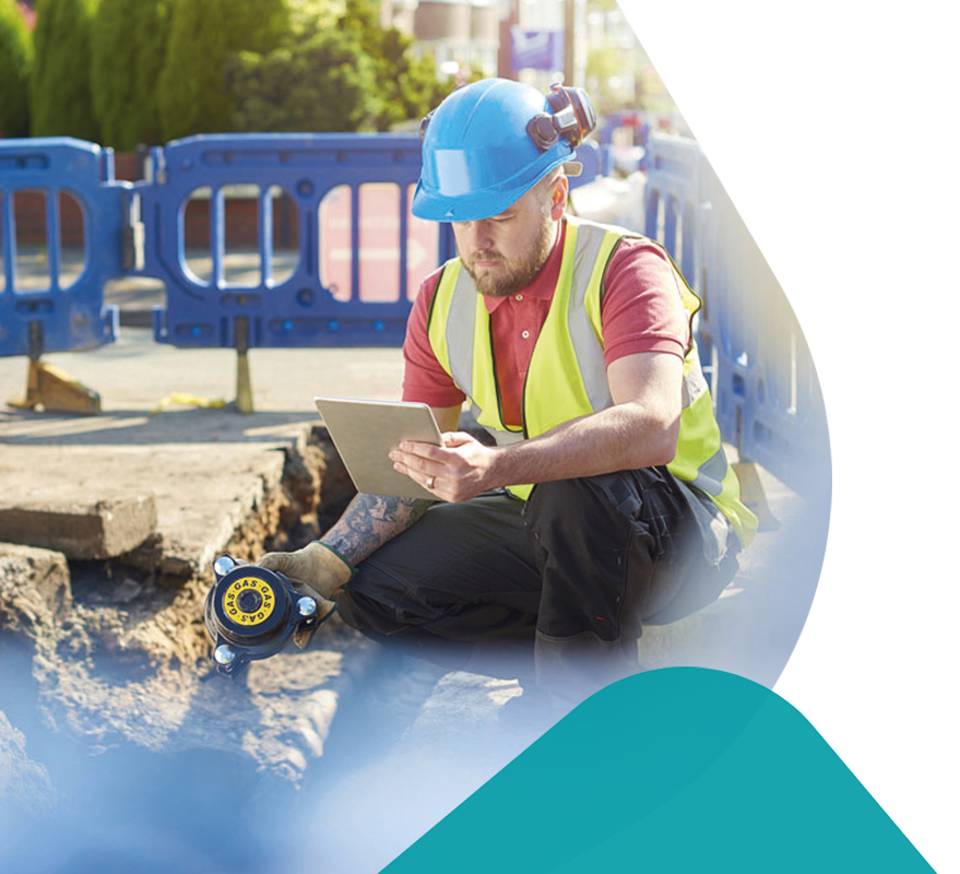 A site works engineer looking down a pavement that is dug up.