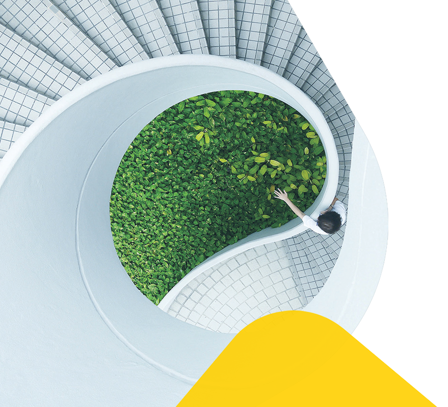 A white spiral stair case, with a woman walking down it.
